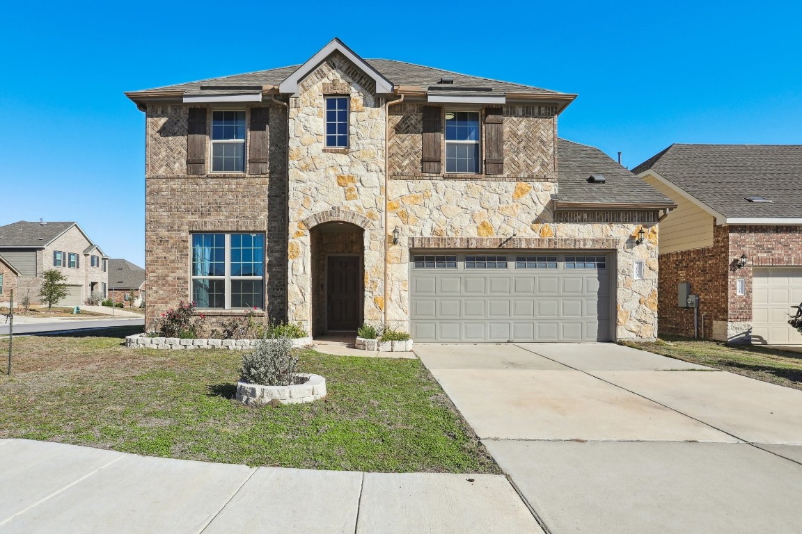 View of front of property featuring a front yard and a garage