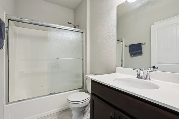 a bathroom with a sink a toilet a mirror and shower