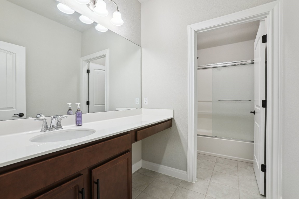 3602 Chaff Lane Pflugerville, TX 78660 - Photo 17 of 28 Bathroom with vanity, shower / bath combination with glass door, and tile patterned floors