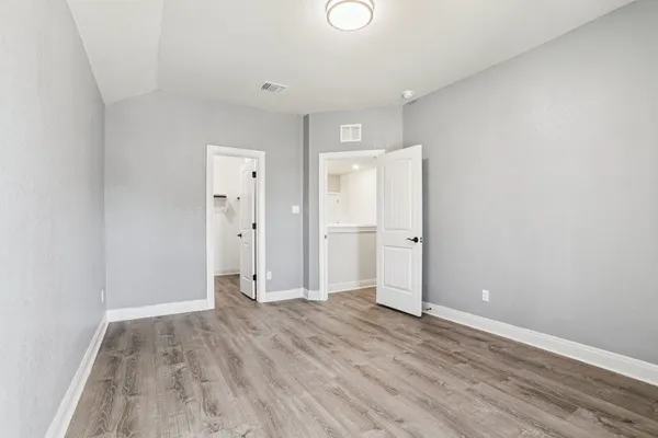 a view of empty room with wooden floor