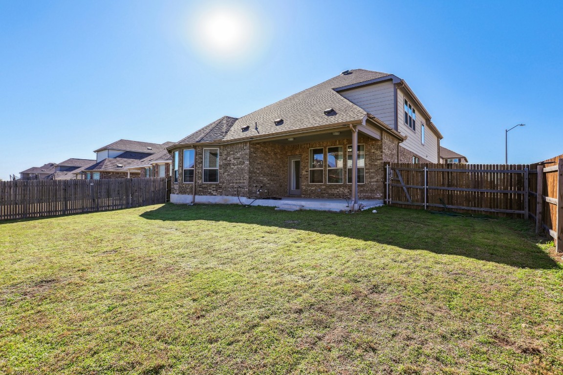 3602 Chaff Lane Pflugerville, TX 78660 - Photo 23 of 28 Rear view of house with a patio and a lawn