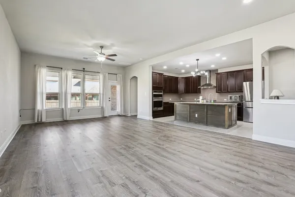 an open kitchen with a refrigerator and a stove top oven