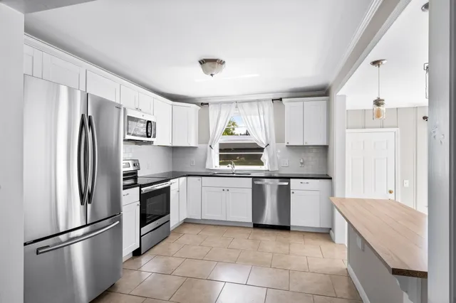 a kitchen with stainless steel appliances granite countertop a refrigerator sink and stove