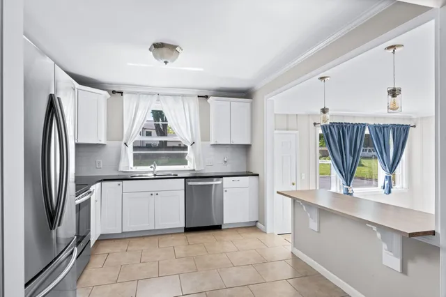 a kitchen with stainless steel appliances granite countertop a refrigerator sink and stove