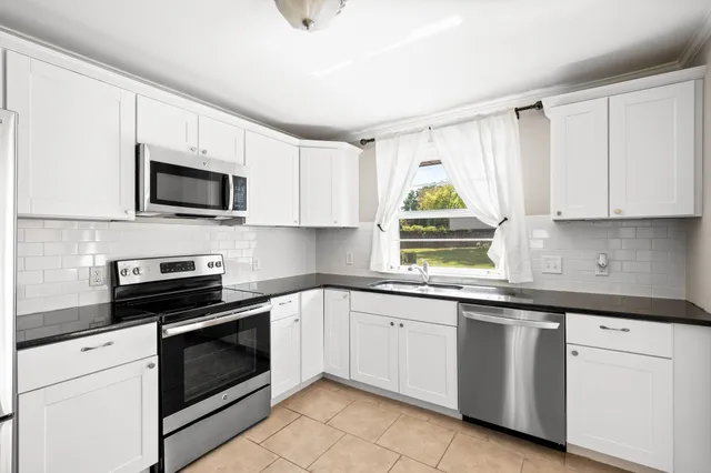 a kitchen with white cabinets and white appliances