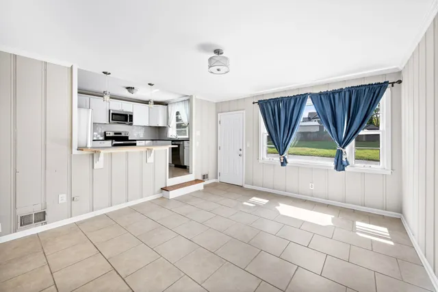 a view of a kitchen with wooden floor and a window