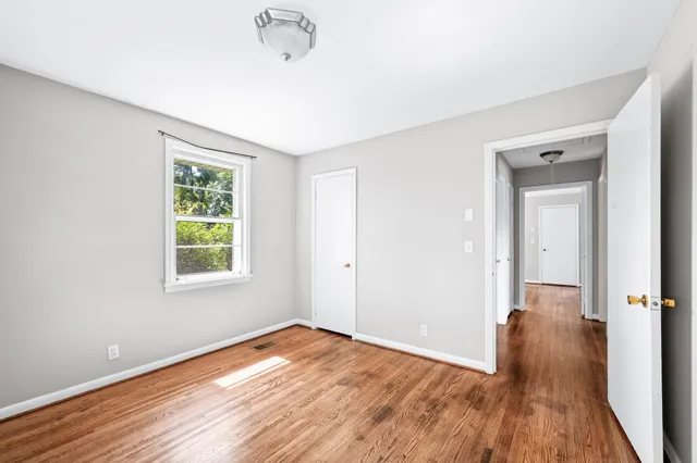 an empty room with wooden floor and a window