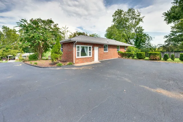 a front view of a house with a yard and trees