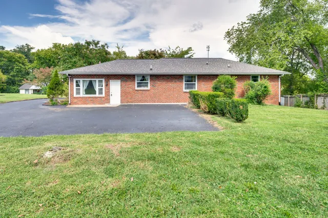 a front view of a house with yard and green space