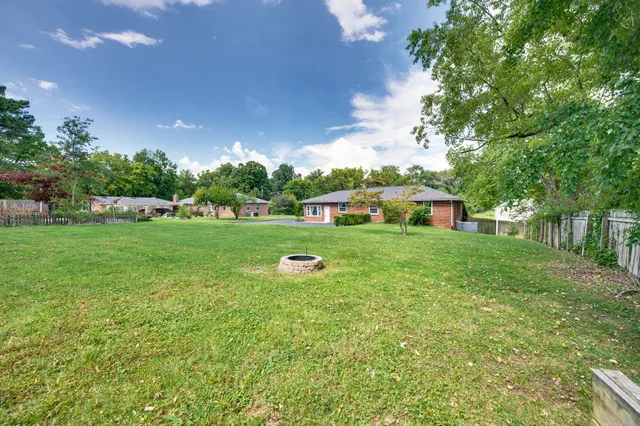 a front view of a house with garden and tree