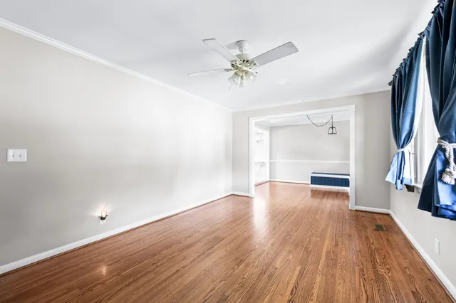 a view of a room with wooden floor and a ceiling fan