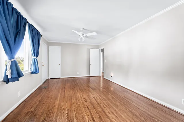 a view of an empty room with wooden floor