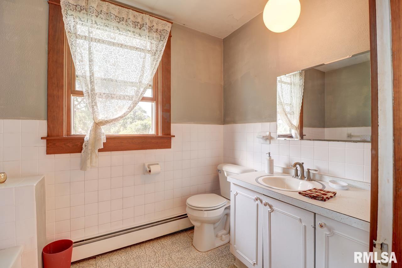 823 14th Avenue South Clinton, IA 52732 - Photo 16 of 27 a bathroom with a granite countertop sink a toilet and a mirror