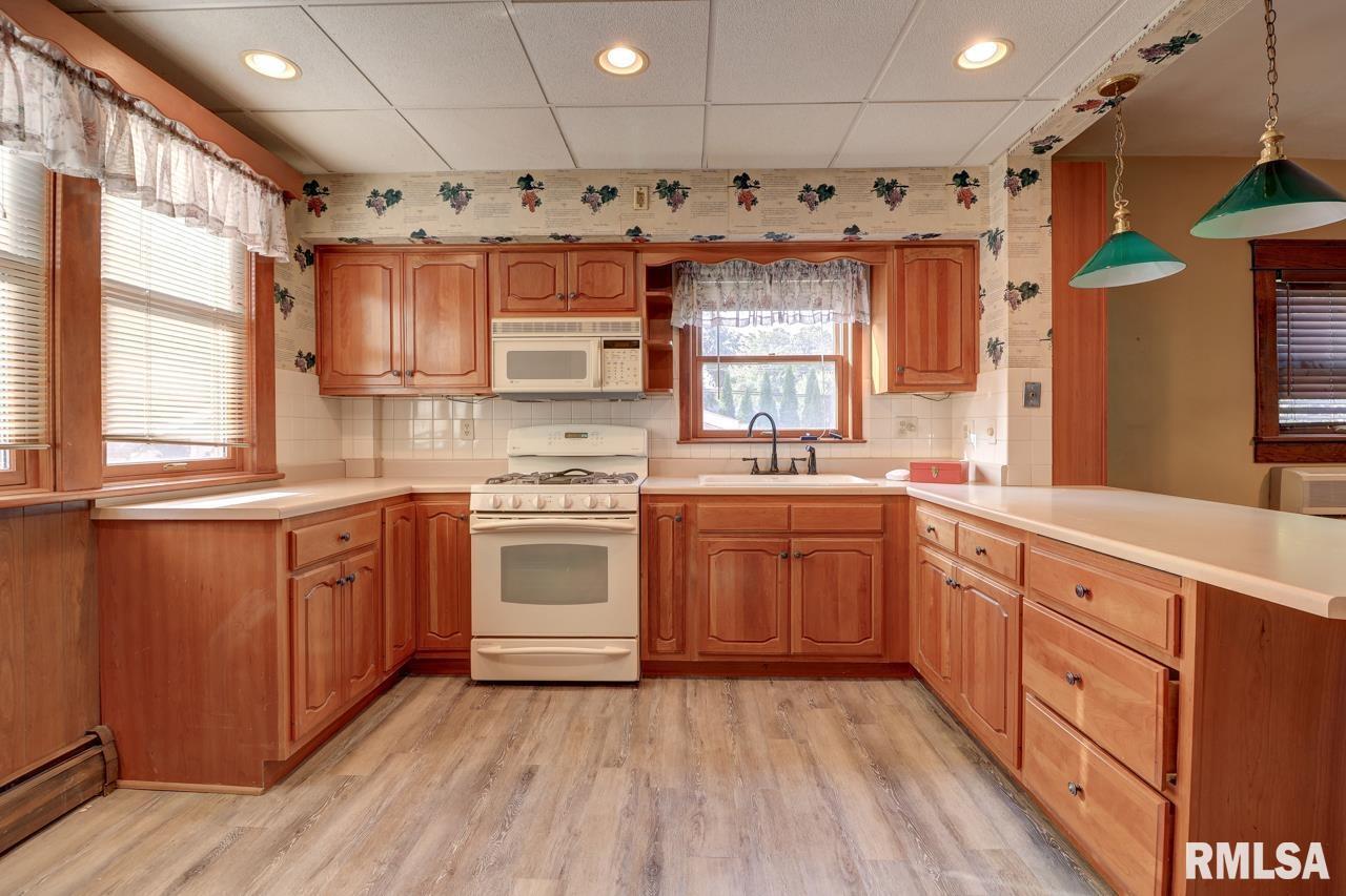 823 14th Avenue South Clinton, IA 52732 - Photo 6 of 27 a kitchen with granite countertop a sink cabinets stainless steel appliances and a large window