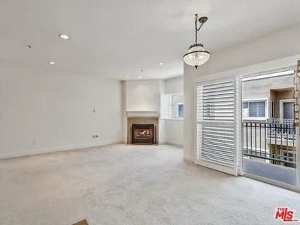 an empty room with windows and fireplace