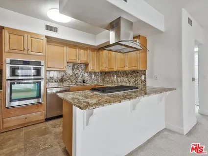 a kitchen with stainless steel appliances granite countertop a sink and a stove