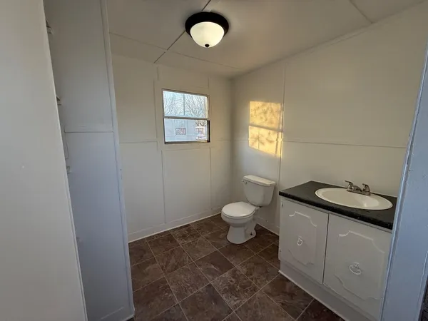 a bathroom with a granite countertop toilet and sink
