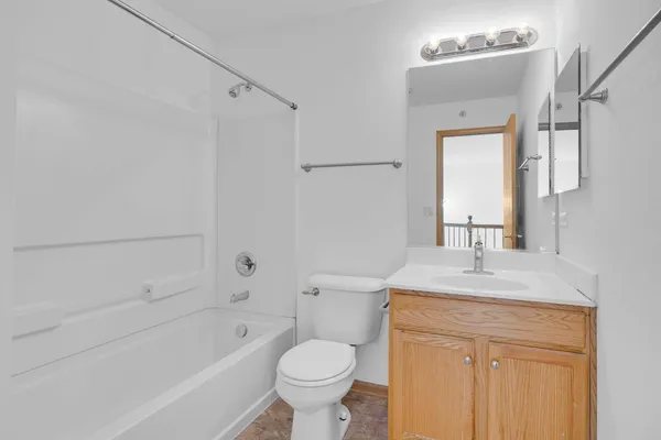 a bathroom with a tub a double vanity sink and mirror