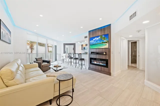 a living room with furniture a ceiling fan and a flat screen tv
