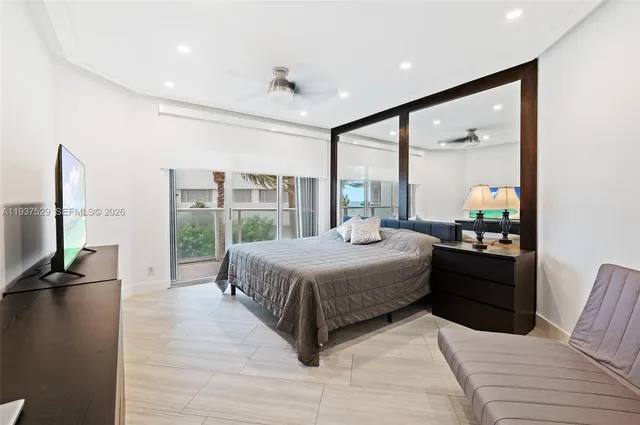 a bedroom with a large bed and a flat tv screen on dresser