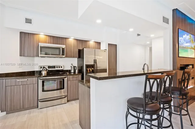 a kitchen with stainless steel appliances granite countertop a stove a sink and a refrigerator