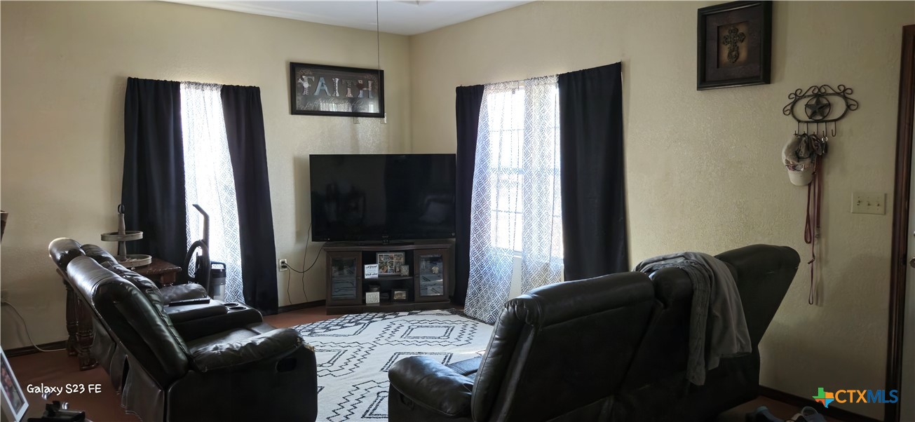 414 Harl Street Pleasanton, TX 78064 - Photo 4 of 28 a living room with furniture a flat screen tv and a refrigerator