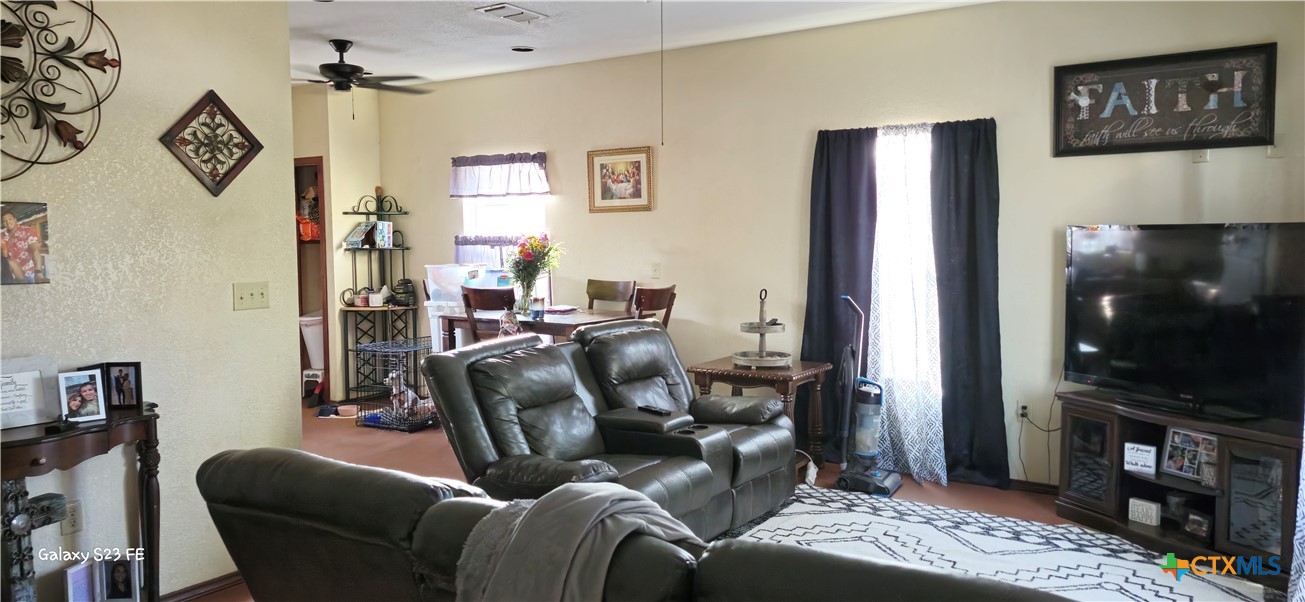 414 Harl Street Pleasanton, TX 78064 - Photo 5 of 28 a living room with furniture a flat screen tv and a table