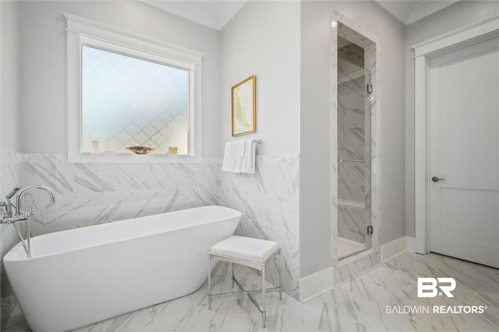 707 Cardamel Court Fairhope, AL 36532 - Photo 20 of 40 Bathroom featuring tile patterned flooring, tile walls, and shower with separate bathtub
