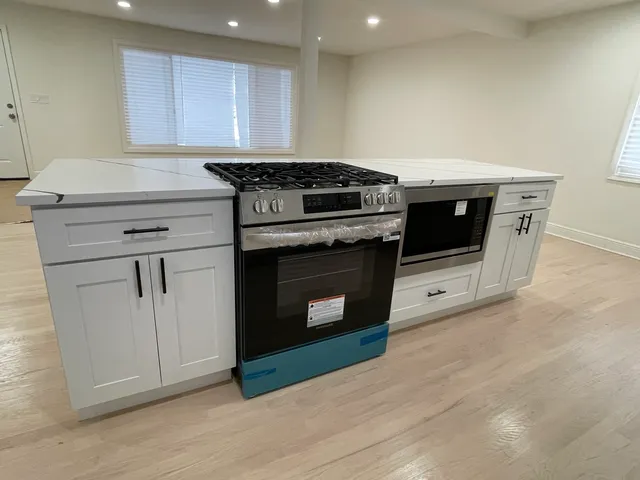 a kitchen with granite countertop a stove top oven and cabinets