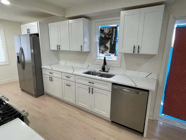 a kitchen with a sink a stove a refrigerator and cabinetry