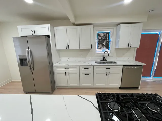 a kitchen with stainless steel appliances a refrigerator sink and cabinets