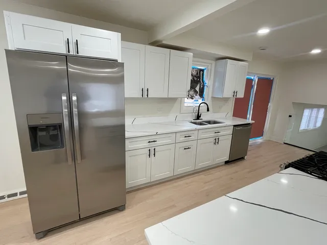 a large kitchen with a large counter top appliances and cabinets