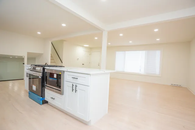 a kitchen with stainless steel appliances granite countertop a stove and a refrigerator