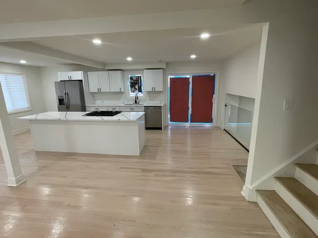 a large kitchen with kitchen island a sink a stove a microwave and a refrigerator