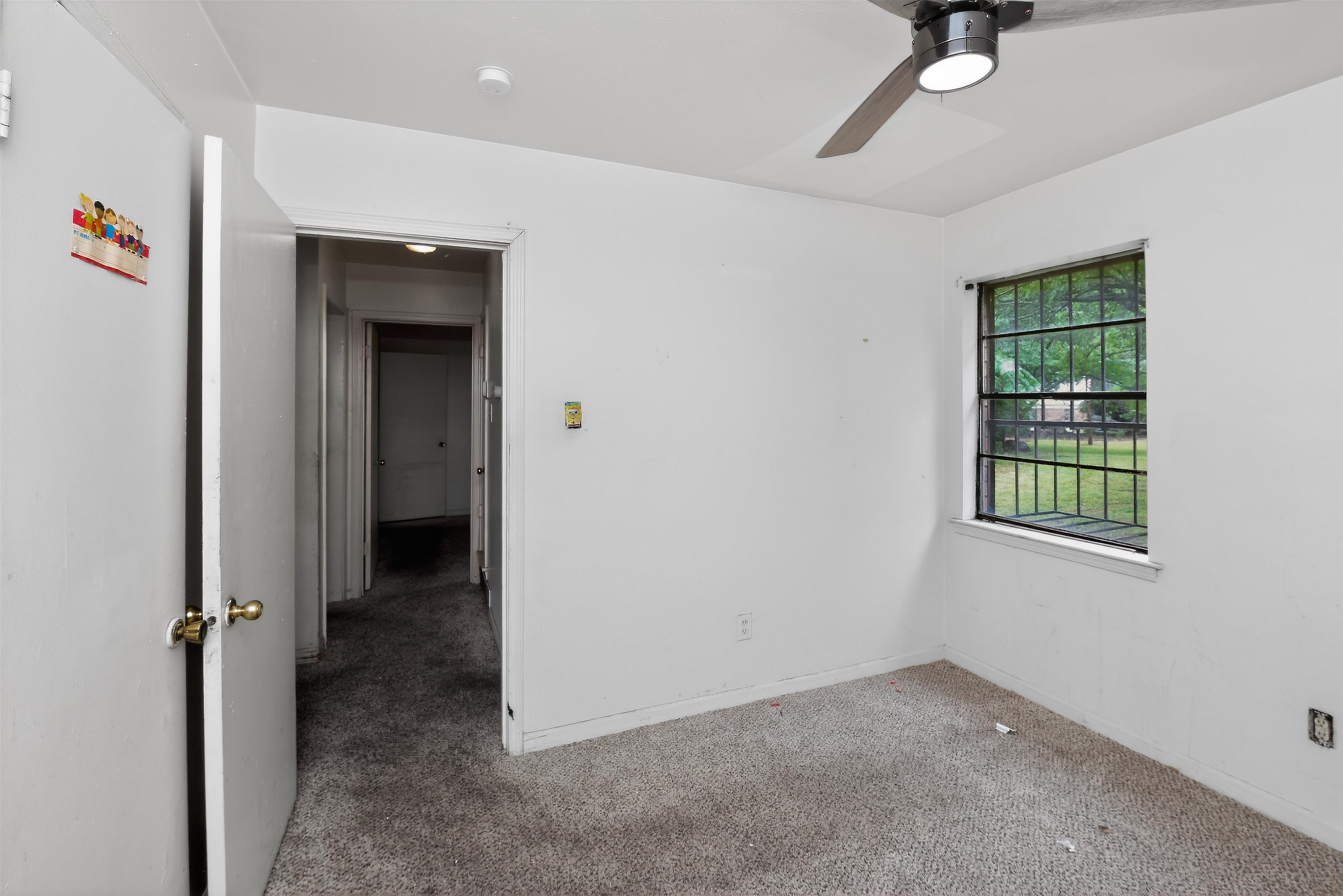 3451 Birdsong Ferry Road Memphis, TN 38118 - Photo 12 of 27 Carpeted room with a ceiling fan, recessed lighting, and a window with security bars overlooking a grassy area