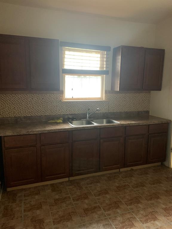 2321 Greer Street Dallas, TX 75215 - Photo 12 of 15 a kitchen with a sink a window and cabinets