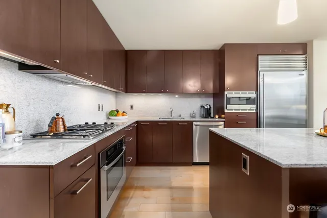 a kitchen with stainless steel appliances granite countertop a sink a stove and a refrigerator