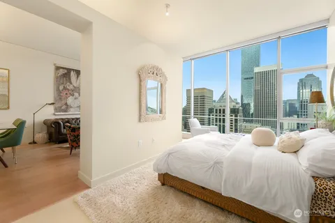 a bedroom with bed and a large window