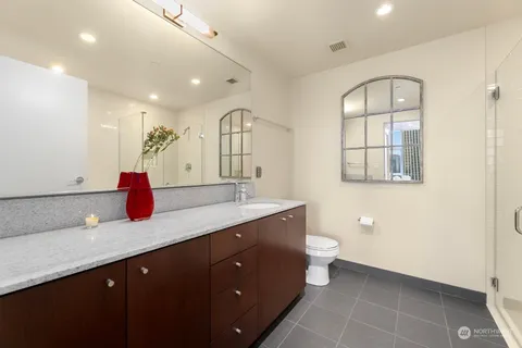 a bathroom with a double vanity sink toilet and a mirror