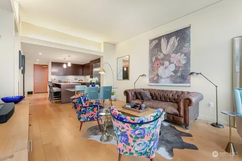 a living room with furniture and a dining table with kitchen view
