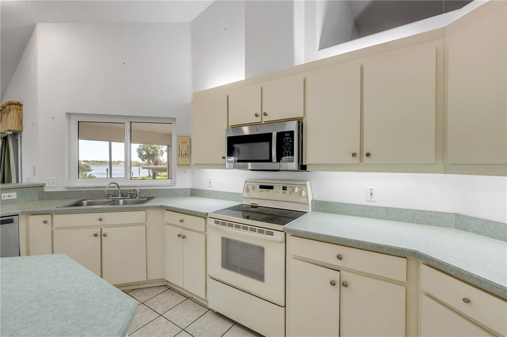 192 Azalea Road Edgewater, FL 32141 - Photo 39 of 94 a kitchen with granite countertop white cabinets and white appliances
