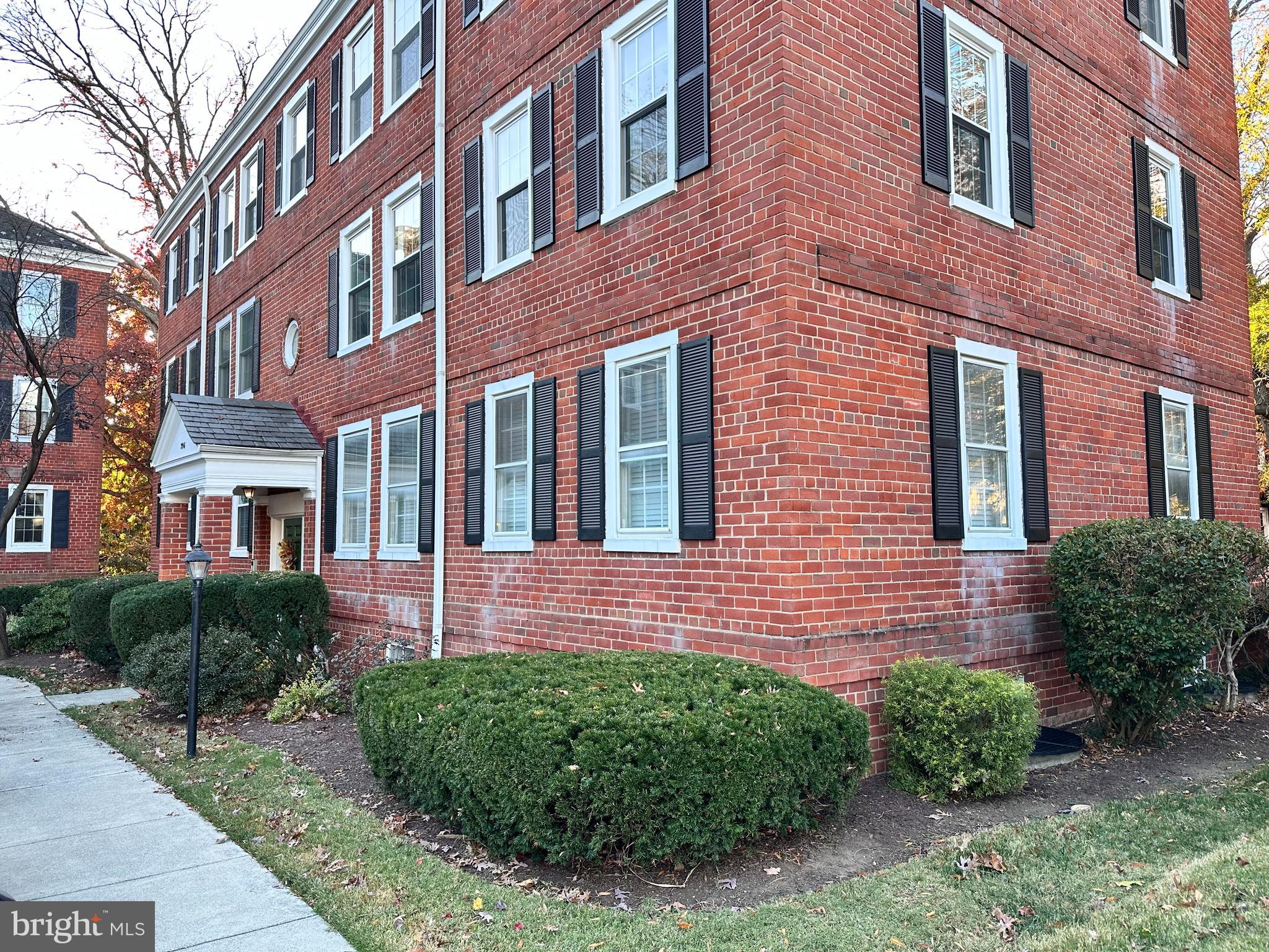 a view of a brick building next to a yard