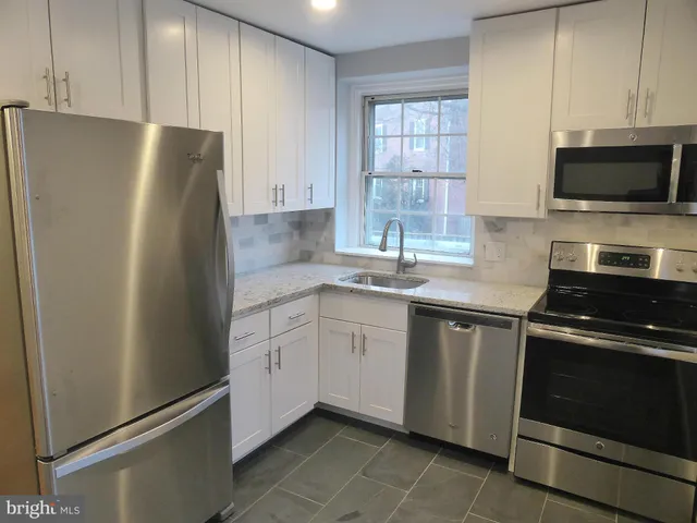 a kitchen with stainless steel appliances a refrigerator stove and sink