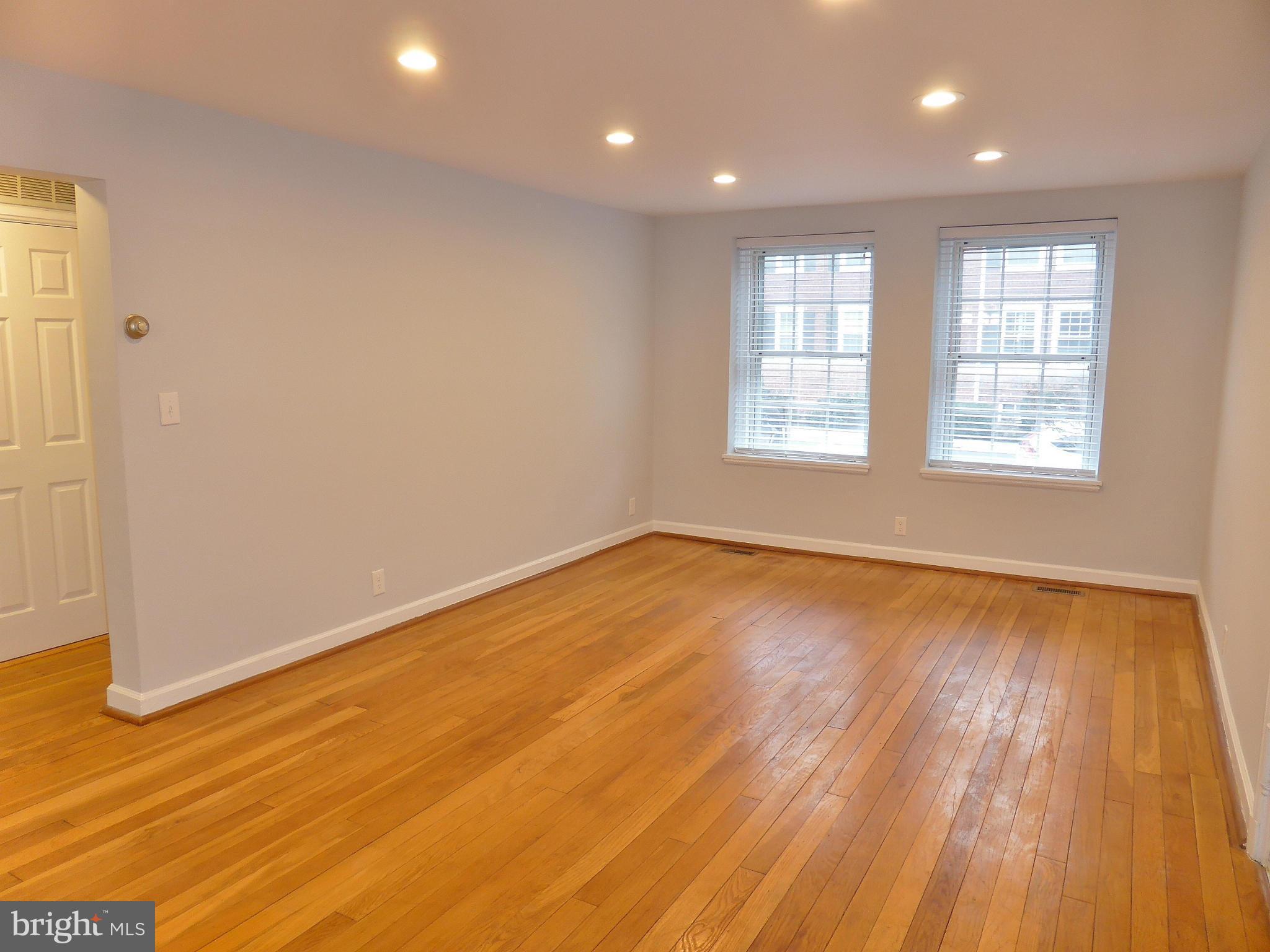 2916 South Buchanan Street, Unit A2 Arlington, VA 22206 - Photo 6 of 19 an empty room with wooden floor and windows