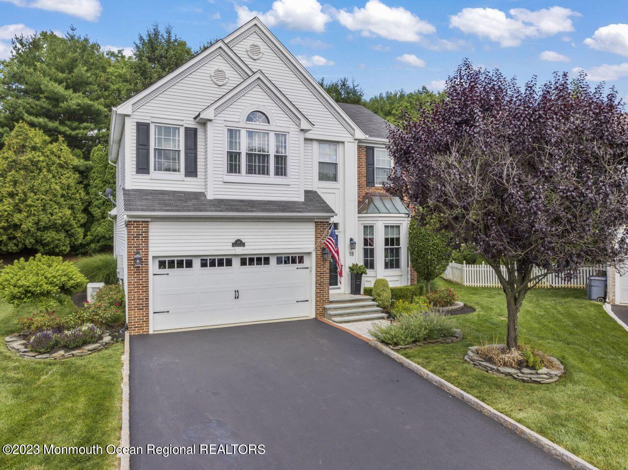 a view of house with yard and garage