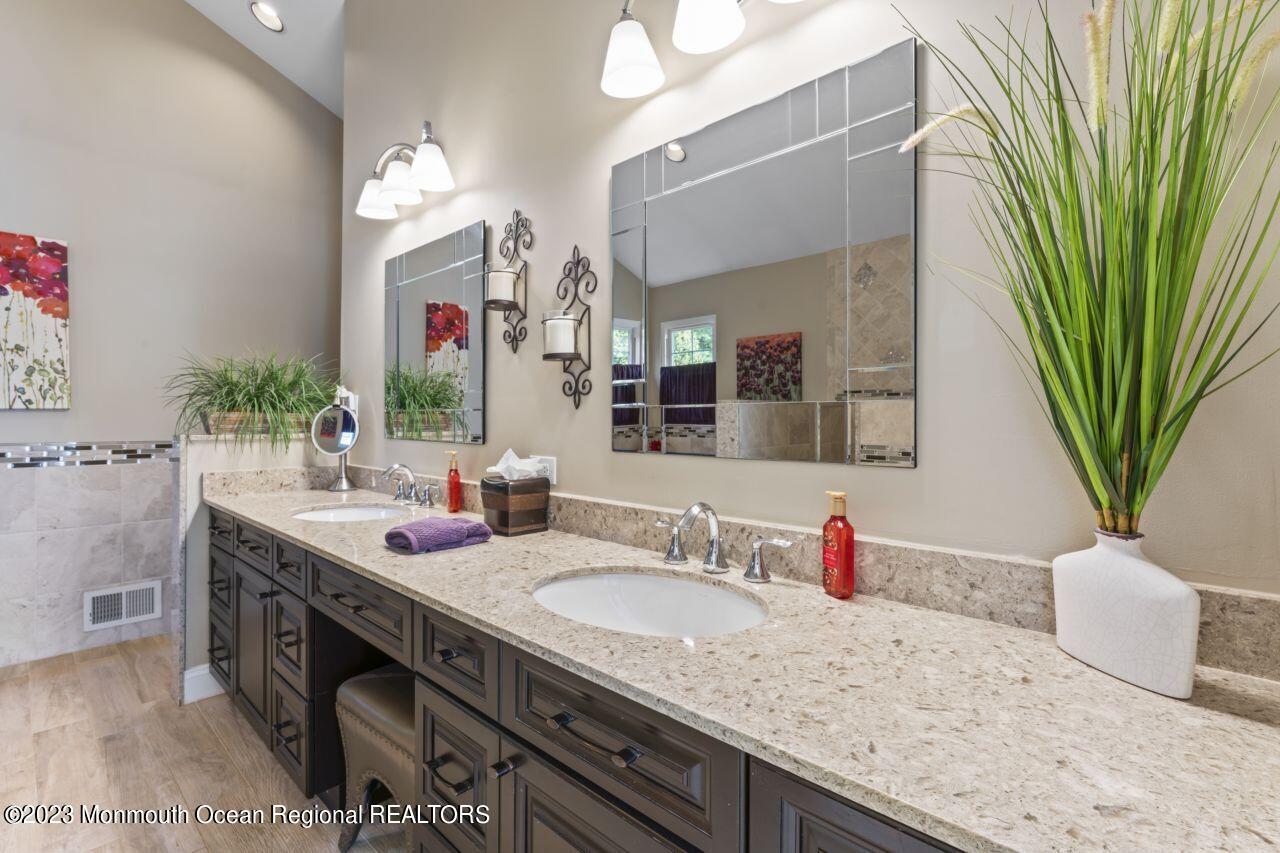 18 Nicholson Key Colts Neck, NJ 07722 - Photo 22 of 46 a bathroom with a granite countertop sink a mirror and a shower
