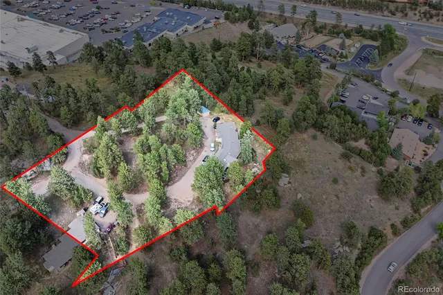 an aerial view of residential house with outdoor space and trees all around