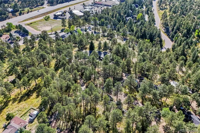 an aerial view of residential house with outdoor space and trees all around