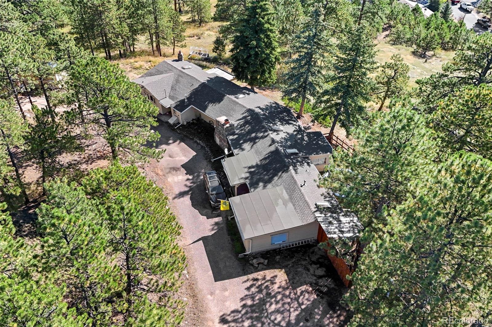3942 Palo Verde Road Evergreen, CO 80439 - Photo 34 of 41 an aerial view of a house with a yard and covered with trees