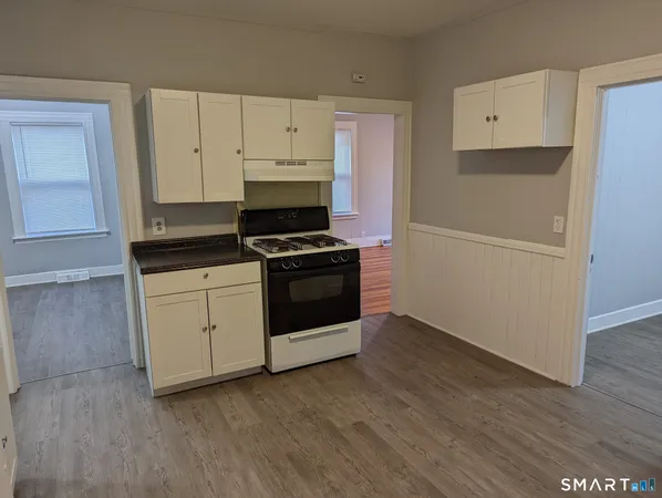a kitchen with white cabinets and white appliances